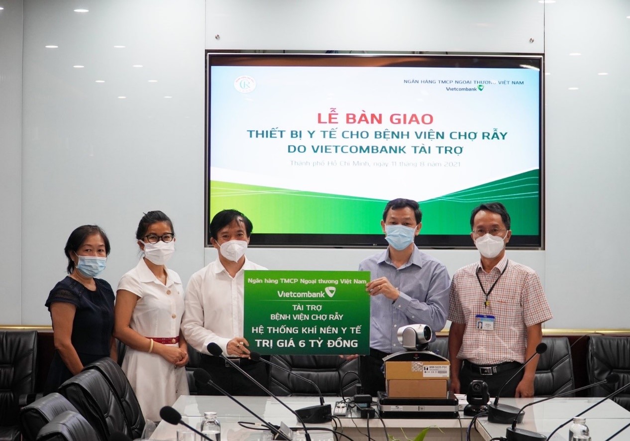 Phó Tổng giám đốc Đặng Hoài Đức (thứ 3 từ trái sang) trao biểu trưng tặng quà cho đại diện Bệnh viện Chợ Rẫy, thầy thuốc ưu tú, Bác sĩ CKII Nguyễn Tri Thức (thứ 2 từ phải sang) - Giám đốc Bệnh viện