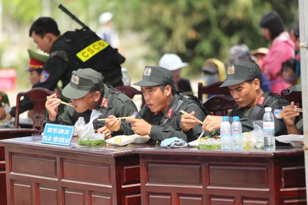 Các chiến sĩ Cảnh sát cơ động tranh thủ ăn trưa tại nơi xét xử