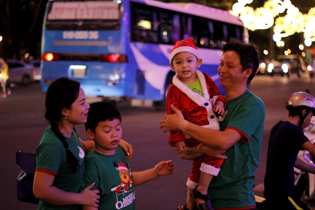 Một gia đình vui vẻ đón giáng sinh trên phố - Ảnh: Phạm Hữu