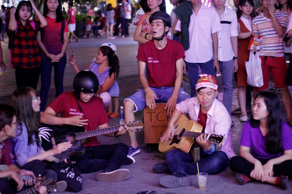 Trên phố đi bộ Nguyễn Huệ, từng nhóm nhỏ các bạn trẻ mang đàn, thi nhau ca hát những bài về giáng sinh khiến không khí trở nên náo nhiệt hơn - Ảnh: Phạm Hữu