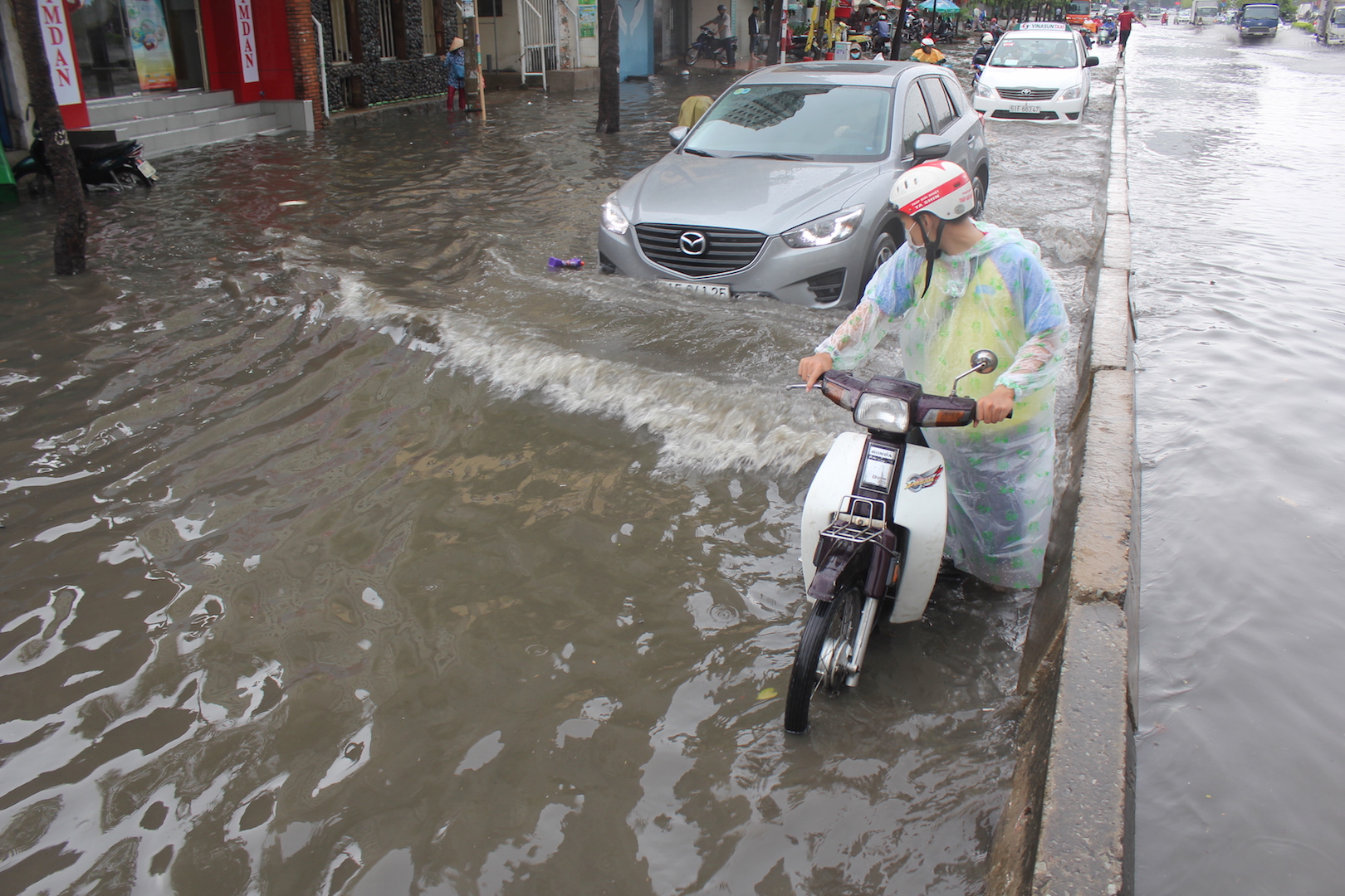 Cơn mưa bắt đầu từ lúc 11 giờ nhưng chỉ trong vào 20 phút con đường Nguyễn Hữu Cảnh đã trở nên ngập lên đến đầu gối 