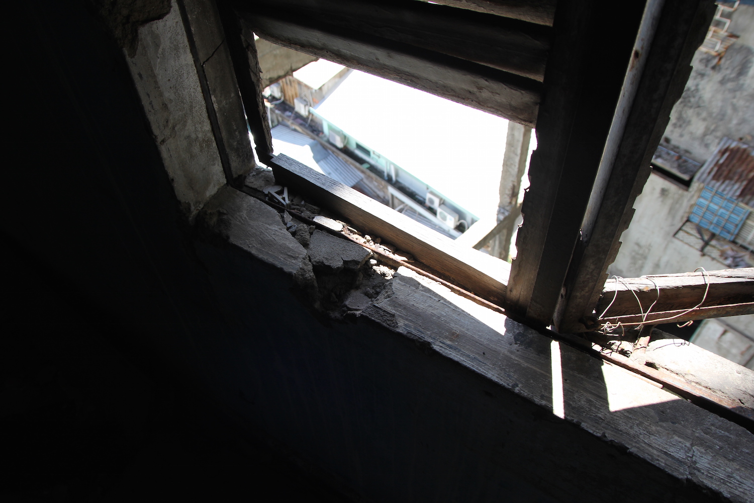 Những mảng bê tông bị bong tróc, cửa sổ phải dùng dây cố định để không bị rơi ra ngoài
