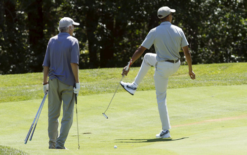 Tổng thống Obama (phải) chơi golf trong chuyến đi nghỉ ở Martha's Vineyard - Ảnh: Reuters