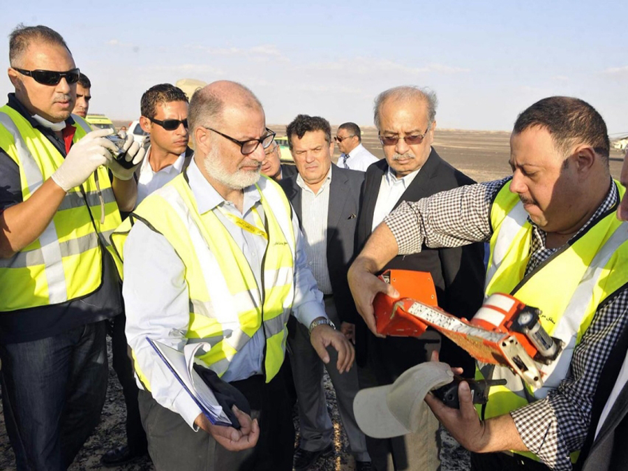 Thủ tướng Ai Cập Sherif Ismail (áo vest đen, ở giữa) cùng các nhà điều tra kiểm tra hộp đen máy bay - Ảnh: AFP