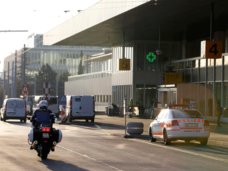 Cảnh sát trên mô tô chạy qua chiếc ô tô cảnh sát ở Geneva hôm 10.12 - Ảnh: AFP