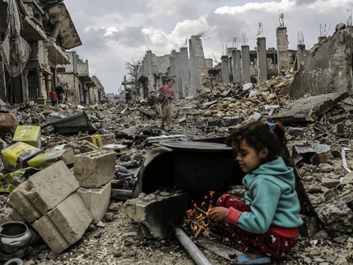 Một bé gái Syria bên đống đổ nát chiến tranh - Ảnh: AFP
