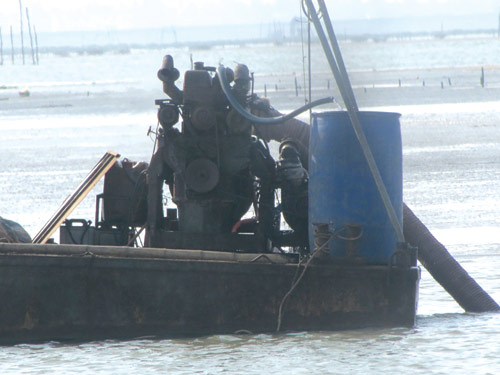 Máy hút cát đặt trên tàu, thọc vòi xuống biển để “ăn” cát 