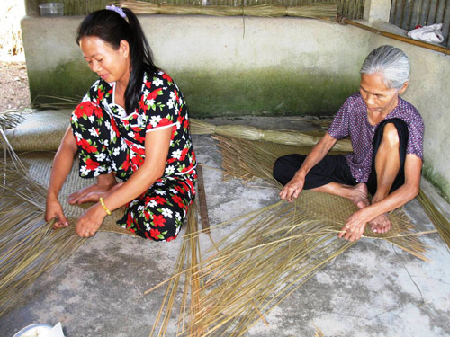 Hai mẹ con Nguyễn Thị Liễu và Nguyễn Thị Bình đang ngồi đan đệm 
