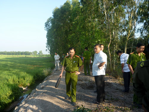 Công an đang khám nghiệm hiện trường và xác chị Phượng nằm dưới ruộng.