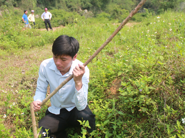 Anh Lê Bá Sơn, con trai ông Tâm bên một cây cao su bị chặt hạ 