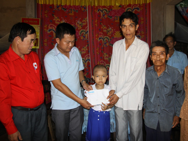  Đại diện báo Thanh Niên (thứ 2 từ trái sang) trao tiền cho cha con anh Toàn.