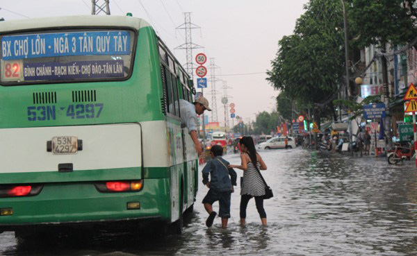 Nhiều người dân lội nước ra giữa mặt đường mới có thể đón được xe buýt 