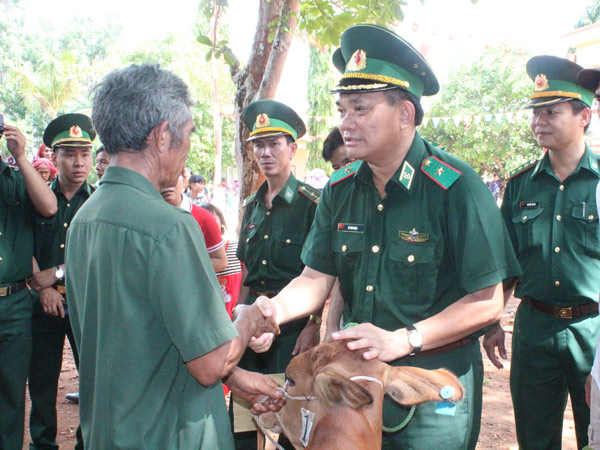 Đại tá Nguyễn Văn Phương- Phó Chính ủy Bộ đội Biên phòng Bình Phước trao tặng bò.