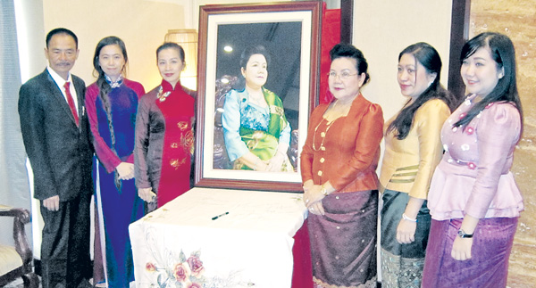 Gia đình ông Chủ tịch XQ (trái) tặng bức chân dung cho phu nhân (bên phải bức tranh) 