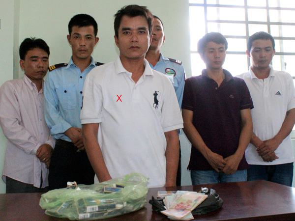 Nghi can Trịnh Văn Hà (dấu X) cùng các đàn em và tang vật bị bắt giữ tại cơ quan công an 