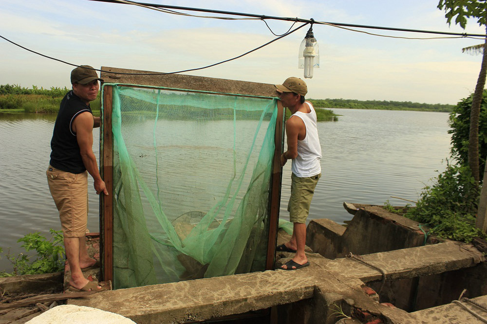 Ông Vươn (phải) và ông Quý sắp xếp lại đống lưới bên khu nhà cũ bị phá dỡ trong vụ cưỡng chế đầu năm 2012.