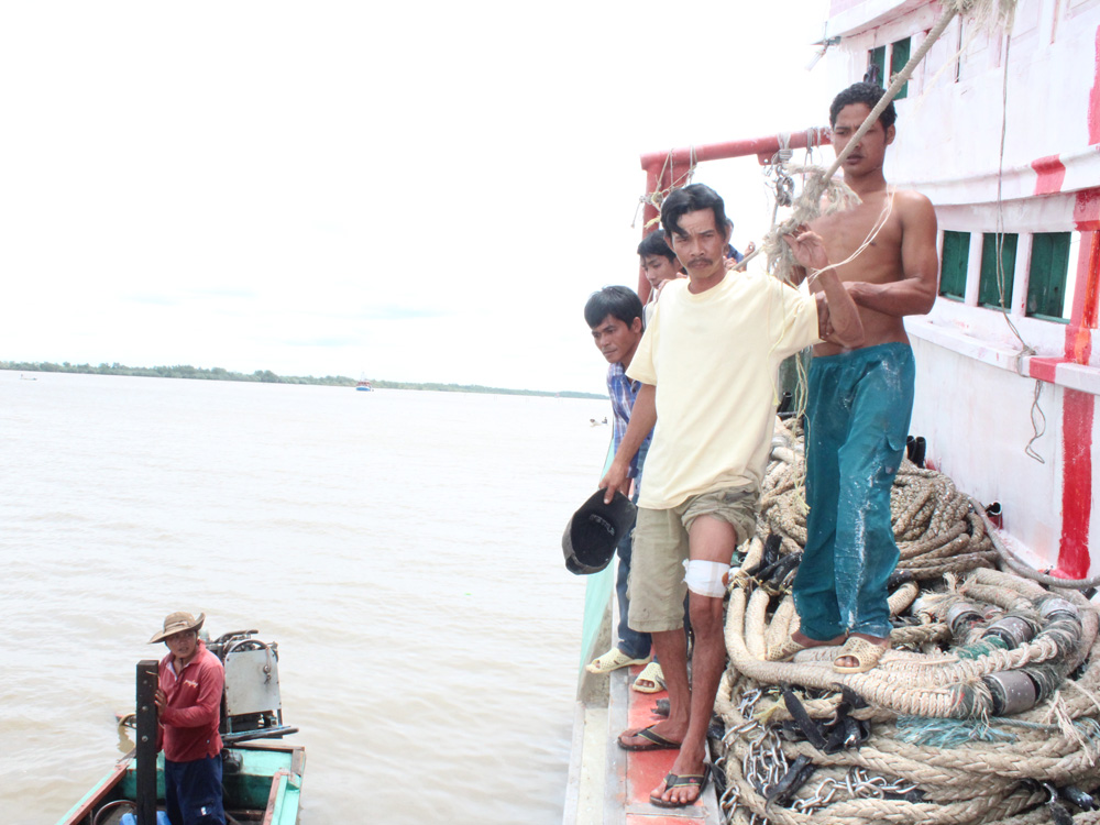 Ngư dân Trần Văn Sáng bị thương ở đùi được chuyển xuống thuyền đưa về bờ cấp cứu chiều 14.9