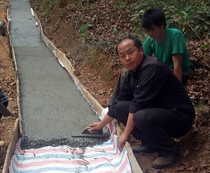 Tráng Seo Pao hướng dẫn người dân xã Hoàng Thu Phố làm đường bê tông 