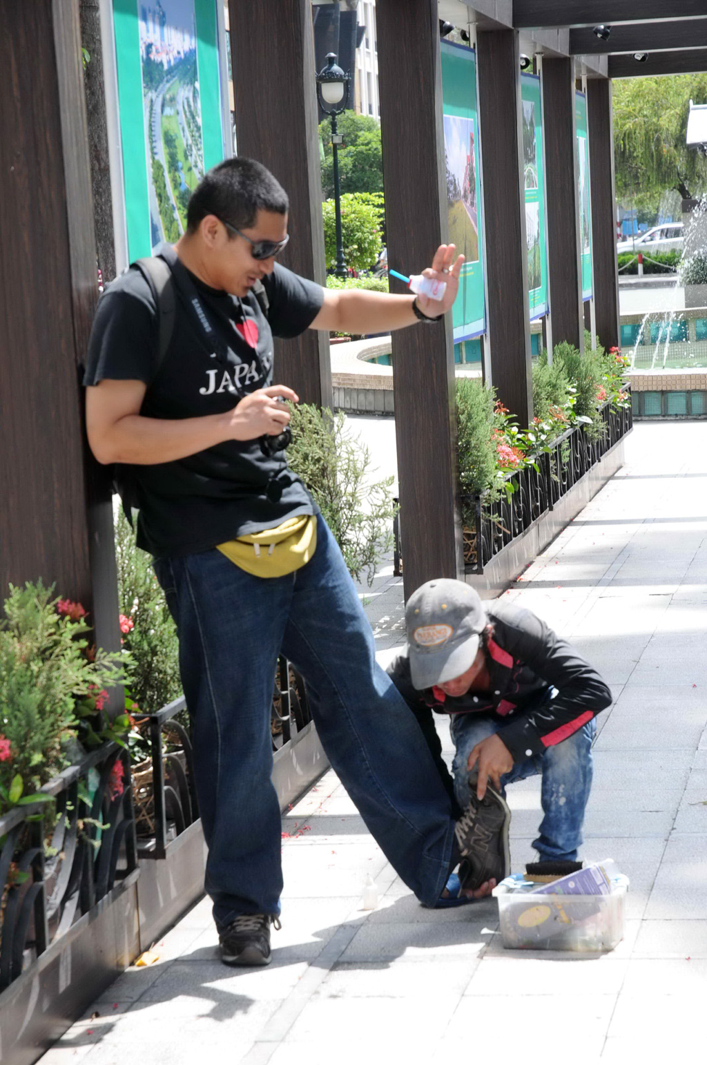 Một người đánh giày đang cố lột giày của khách du lịch tại TP.HCM 