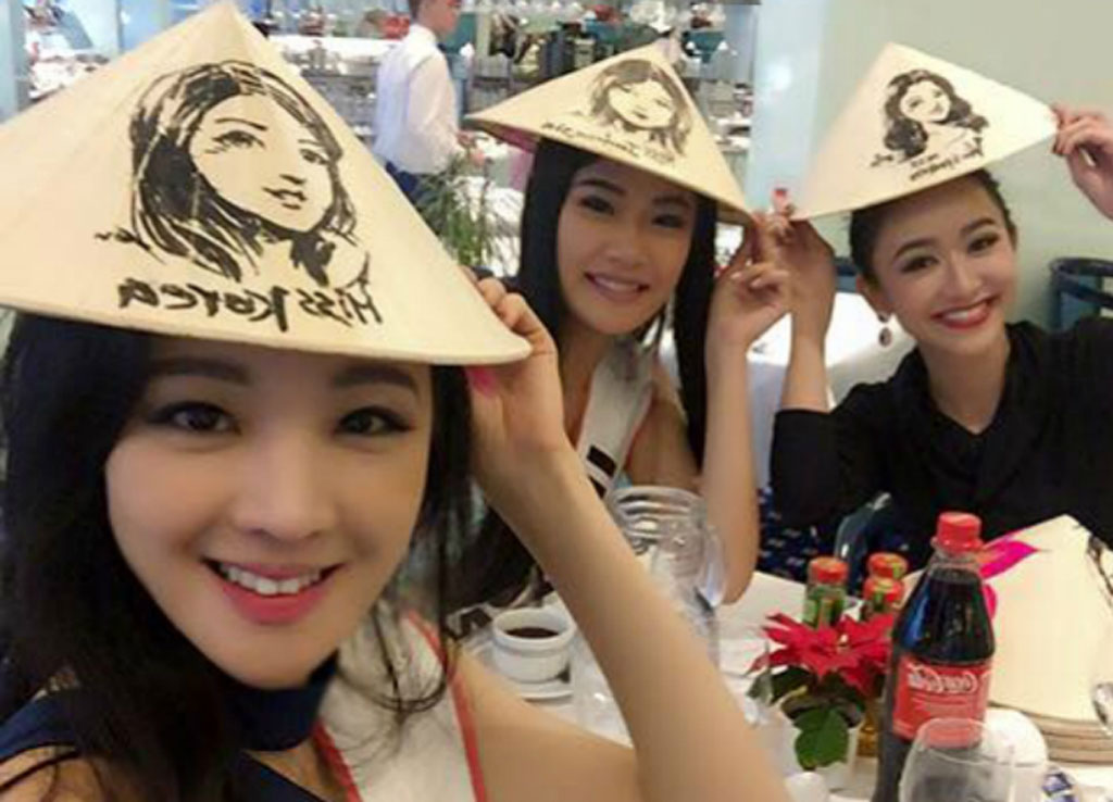Người đẹp Việt Nam dành tặng hơn 60 thí sinh nước khác mỗi người một chiếc nón lá có hình chân dung của họ - Ảnh: NVCC
