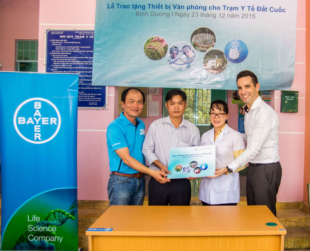 Ông Torsten Velden – Tổng Giám Đốc Bayer Việt Nam (bìa phải) và ông Lê Minh Lộc (bìa trái) – Giám đốc nhà máy Thuốc thú y Bayer Việt Nam trao tặng thiết bị văn phòng cho đại diện trạm y tế xã Đất Cuốc.