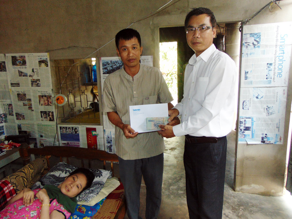 Đại diện Báo Thanh Niên trao tiền 116,1 triệu đồng của bạn đọc giúp đỡ cho cô giáo Phạm Thị Luyên (ngụ Bà Rịa- Vũng Tàu) gặp tai nạn giao thông dẫn đến đời sống thực vật- Ảnh: Minh Anh 
