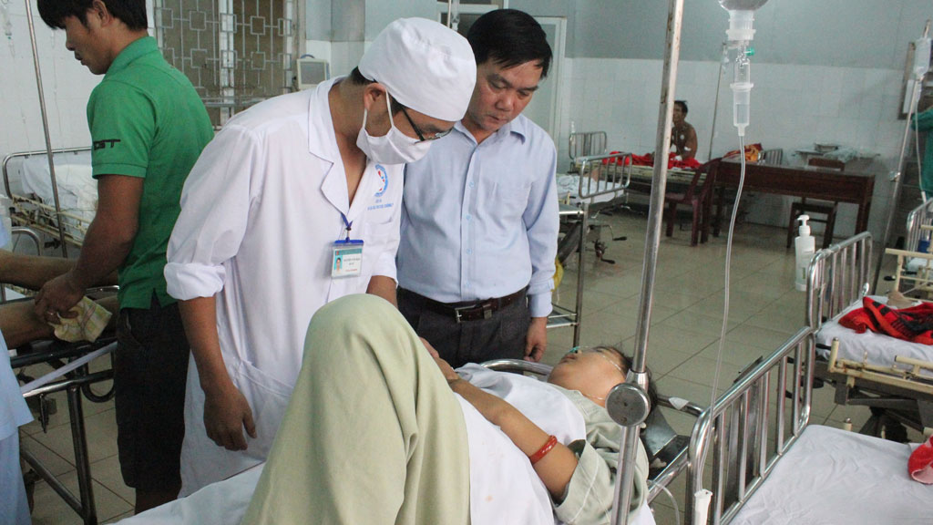 Giám đốc Sở Y tế Quảng Ngãi (người đứng bên phải) thăm hỏi sức khỏe các nạn nhân bị tai nạn giao thông đang điều trị tại Bệnh viện đa khoa Quảng Ngãi - Ảnh: Hiển Cừ