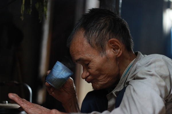 “Người rừng” cha uống nước chè giữ ấm - Ảnh: Trác Rin