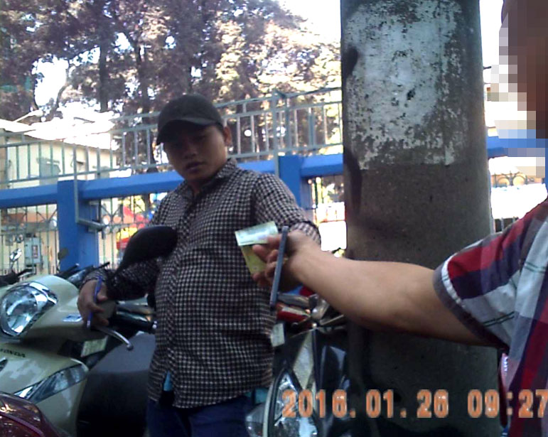 Thanh niên trên đường Nguyễn Văn Chiêm thu 20.000 đồng giữ ô tô ngày 26.1.2016 