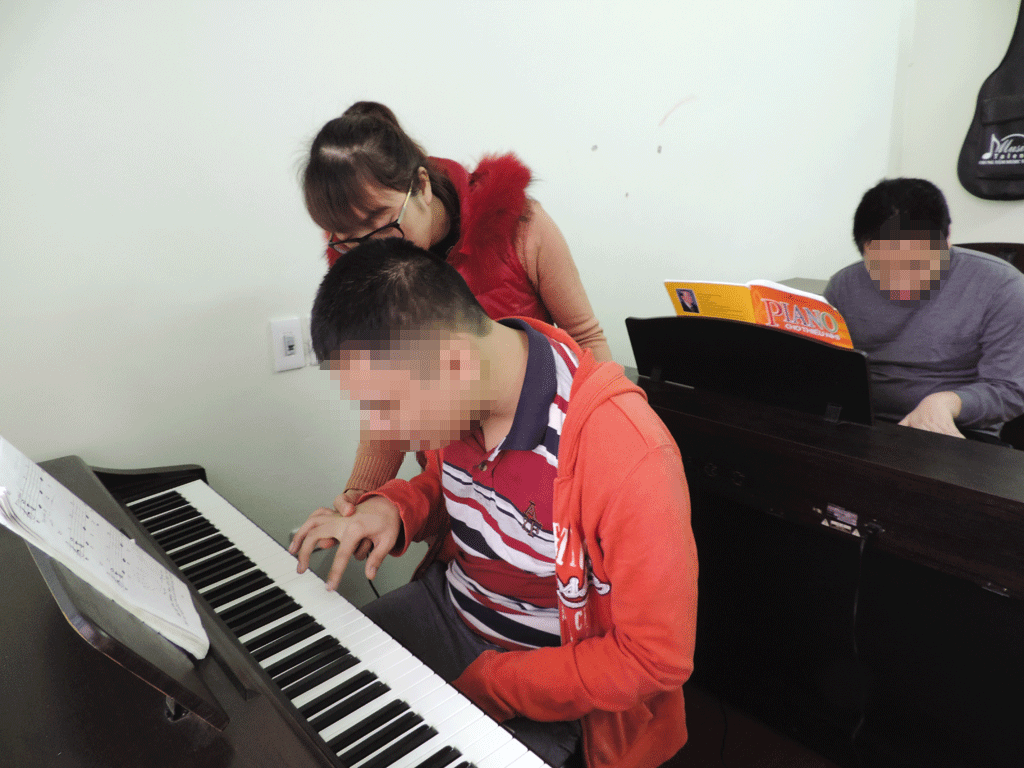 Các cô giáo ở đây phải luôn ở kiên trì dạy cho các em từng nốt nhạc - Ảnh Trần Hồ