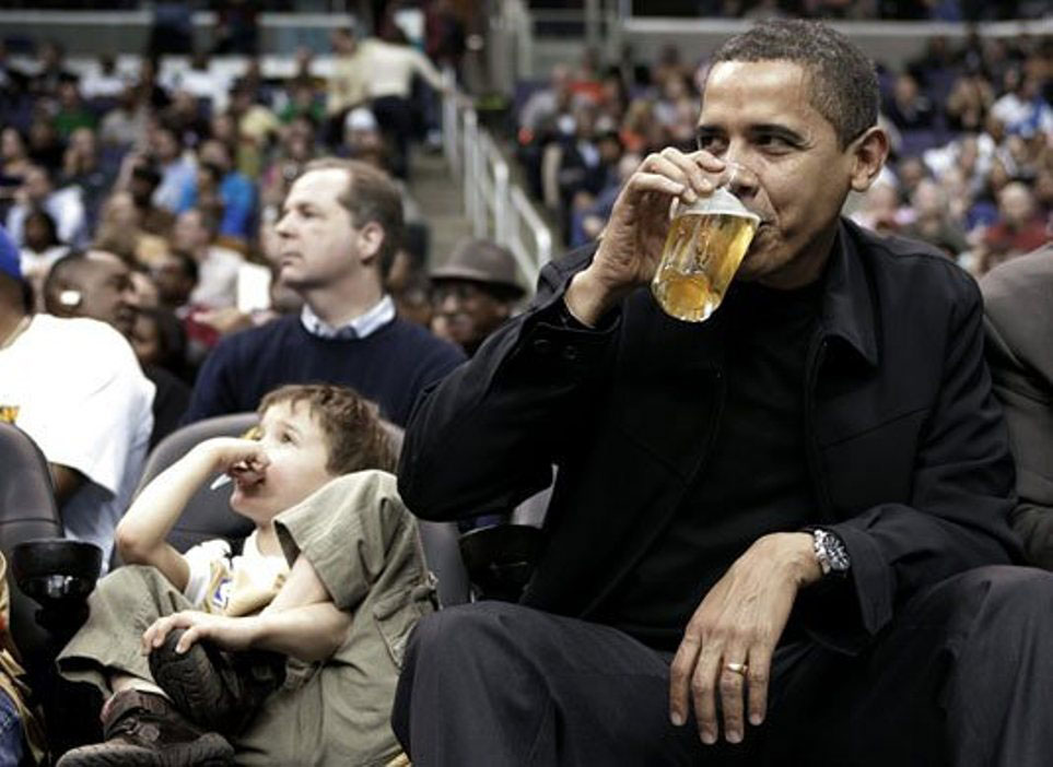 Tổng thốbg Obama uống bia khi đang dự khán một trận đấu của giải NBA giữa CLB Chicago Bulls và CLB Washington Wizards. Ảnh: Reuters