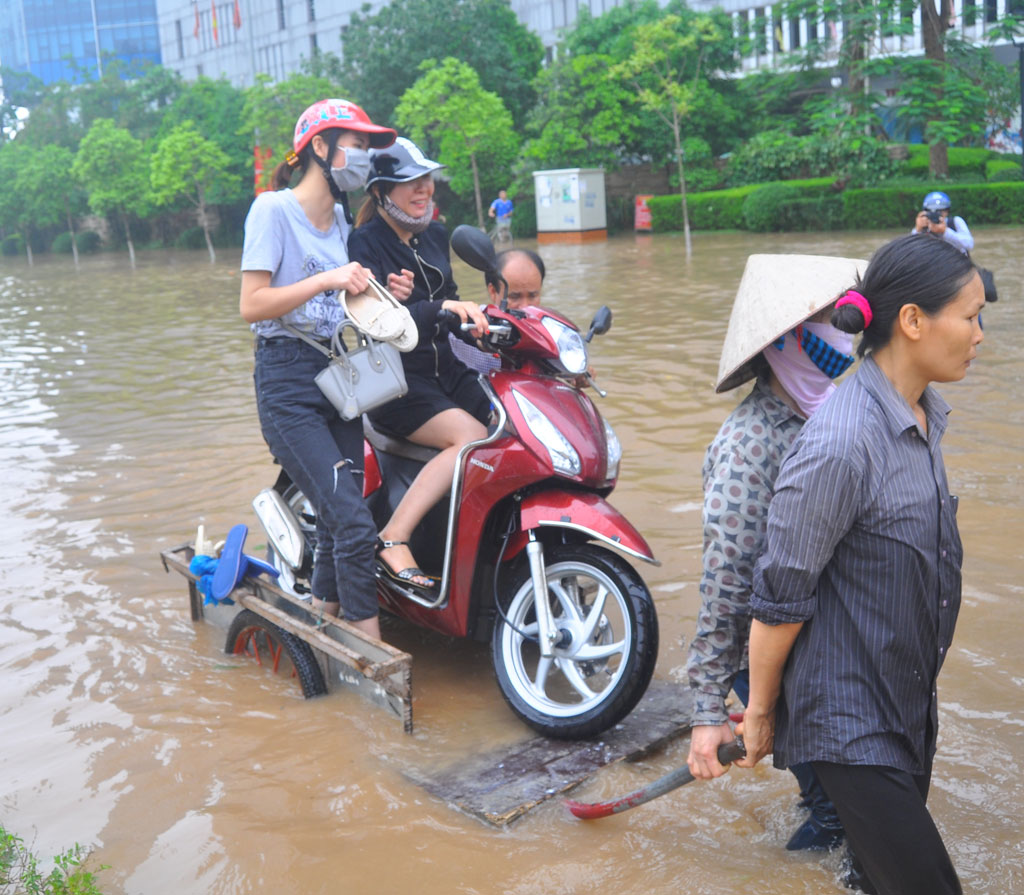 Dịch vụ kéo xe chở người và phương tiện qua đường ngập Dương Đình Nghệ Ảnh: Đàm Duy