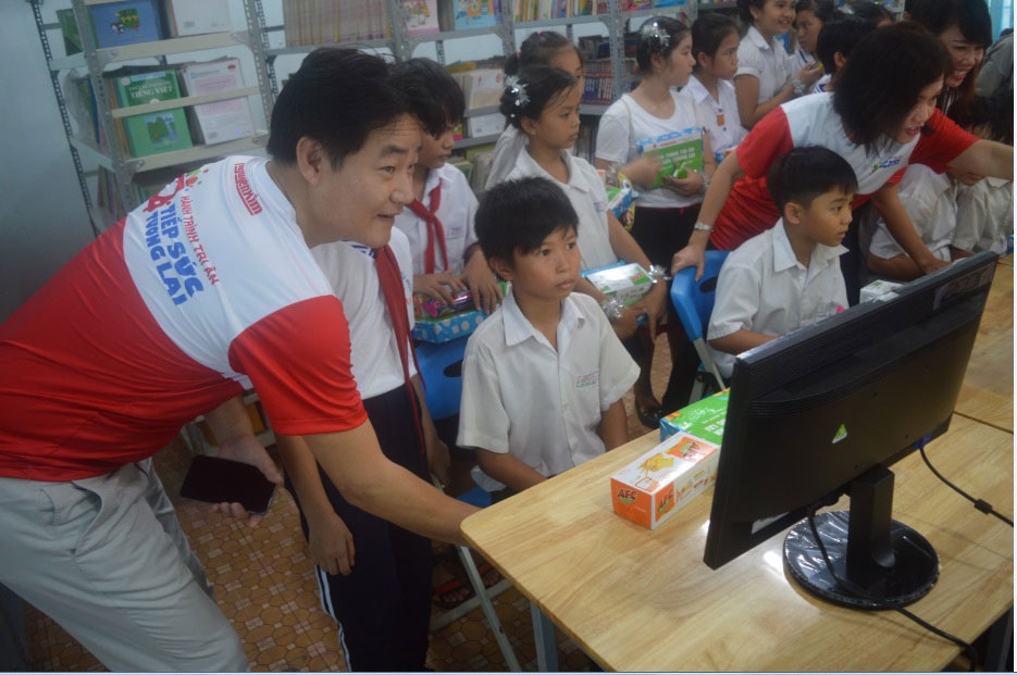 Ông Kim Tae Hyun - Phó Tổng Giám đốc Vận hành Nguyễn Kim hướng dẫn các em học sinh sử dụng thư viện điện tử