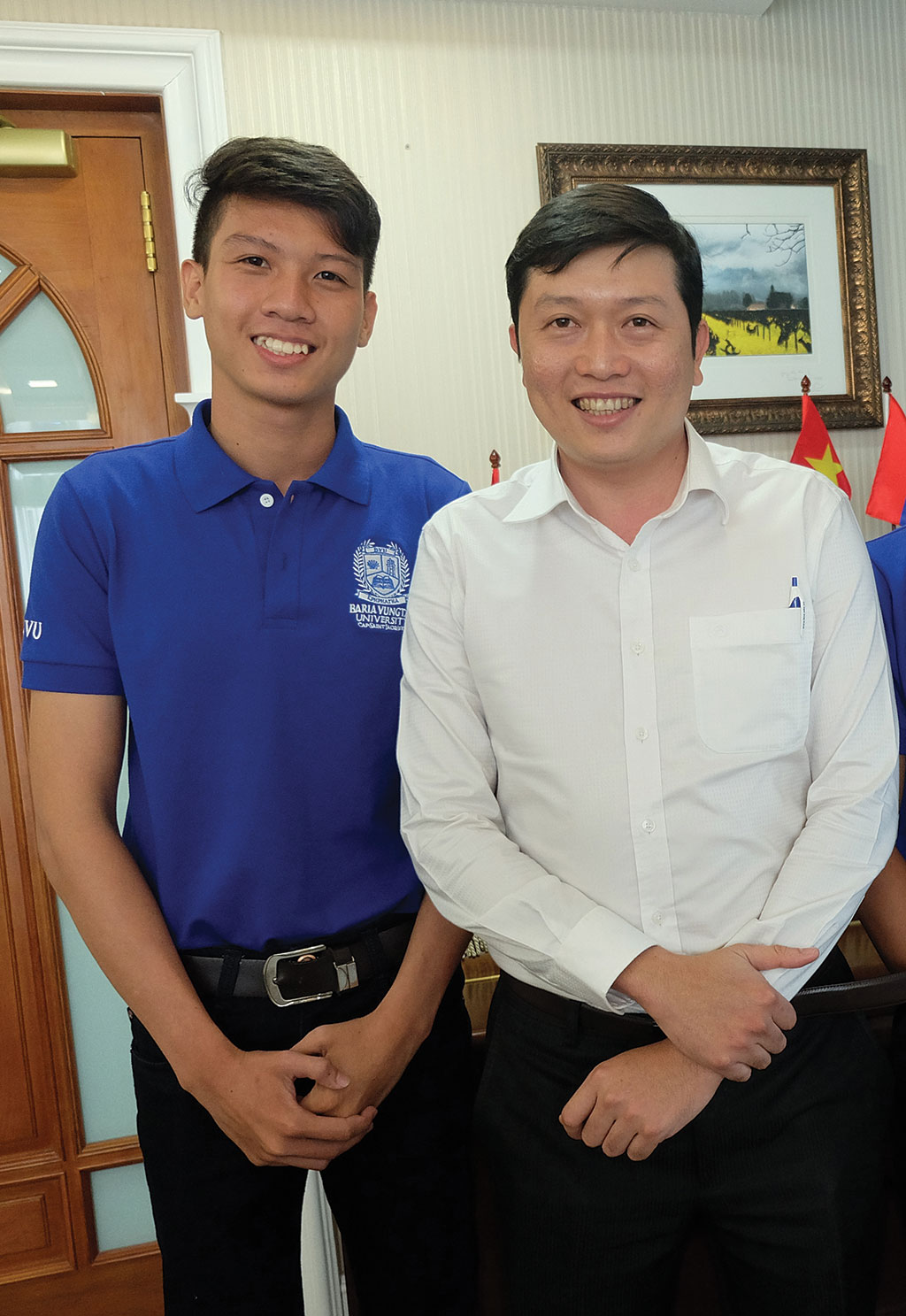 Dương Chí Tuấn (trái) trong đồng phục BVU và thầy Nguyễn Minh Trung - Phó phòng Đào tạo BVU