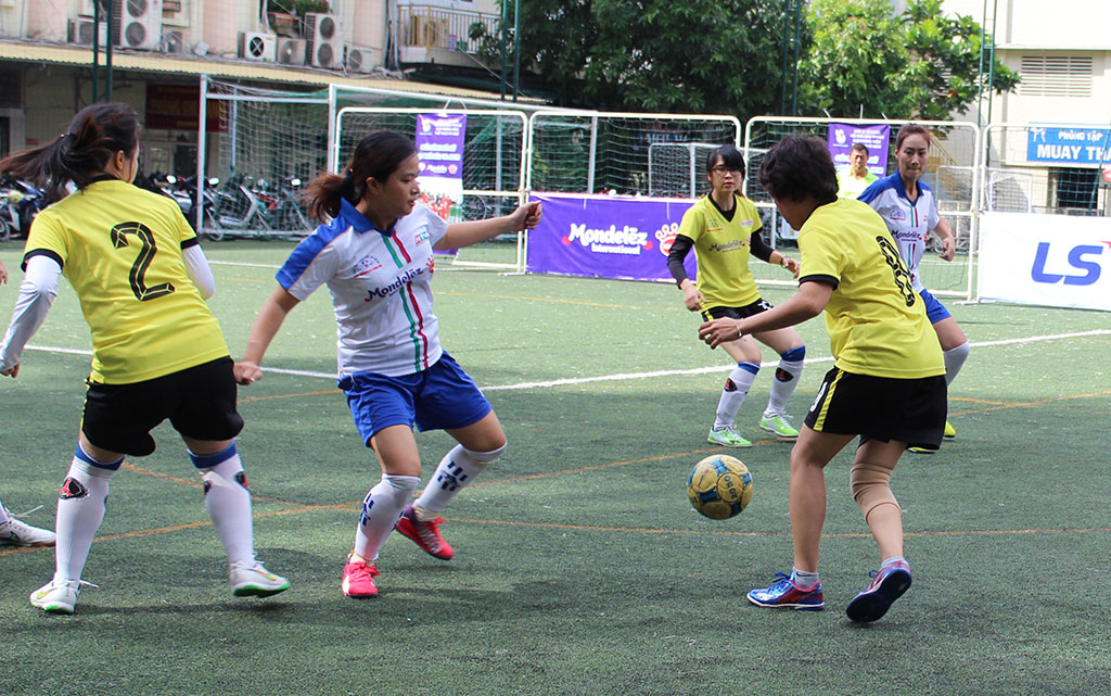 Các cầu thủ Sài Gòn Giải Phóng (áo vàng) tranh bóng với các cầu thủ HTV (áo trắng)