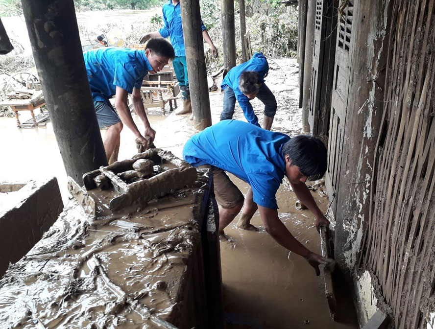 Thanh niên tình nguyện giúp người dân bản Ta Mo (xã Mường Bú, H.Mường La, Sơn La) dọn dẹp bùn đất sau lũ Ảnh: Nguyễn Thảo