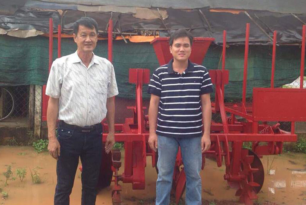  Ông Trần Quốc Hải và con trai bên máy trồng mì Ảnh: Quốc Thanh