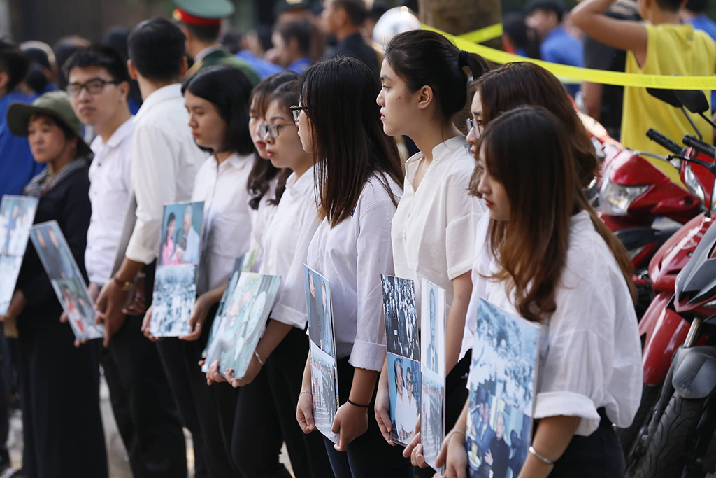 Nhiều học sinh mang theo di ảnh cố Tổng bí thư Đỗ Mười đứng hai bên đường bên ngoài nhà tang lễ