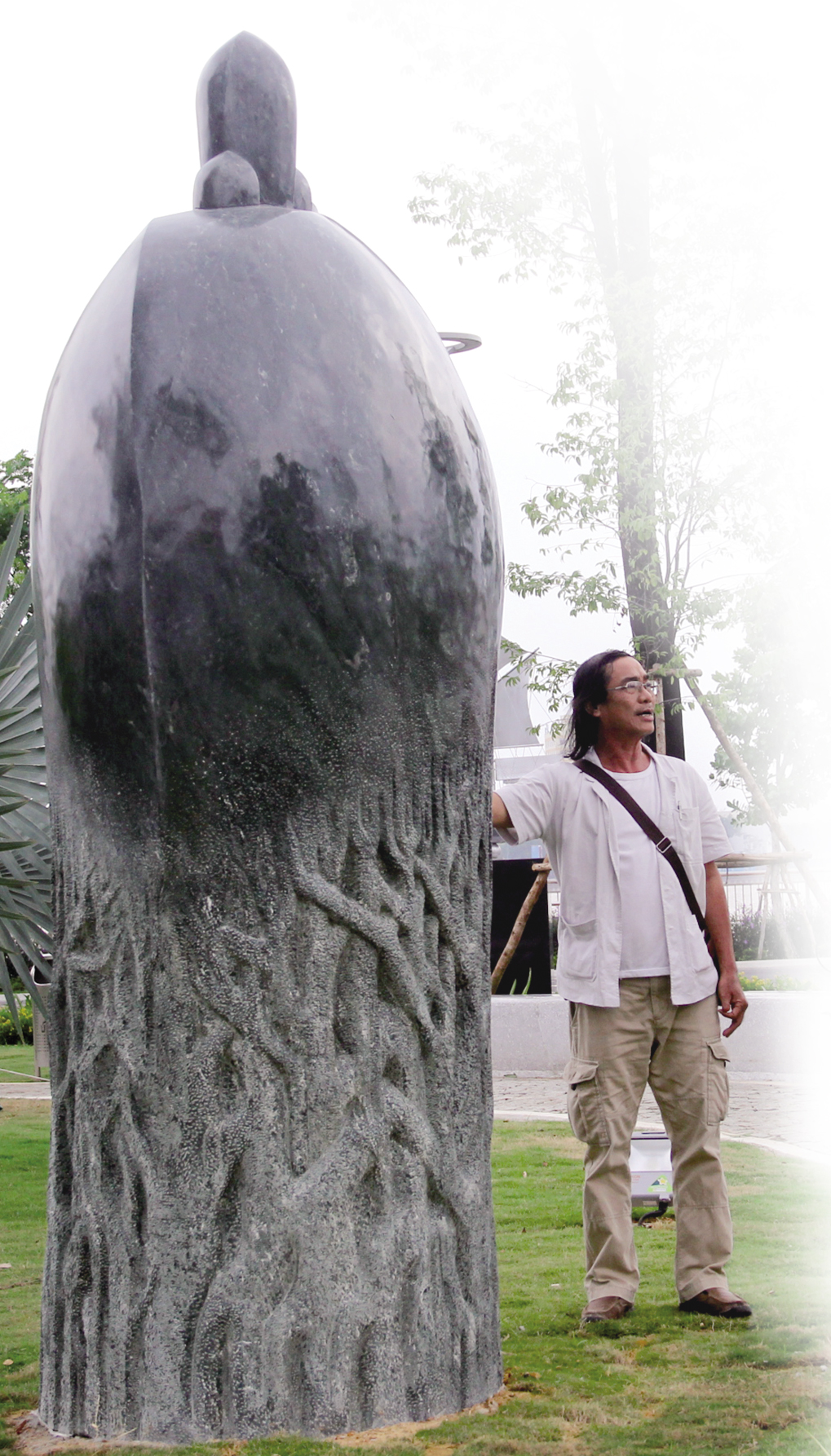 Nghệ nhân Nguyễn Long Bửu bên tác phẩm Khởi nguyên tại Vườn tượng APEC Ảnh: V.T