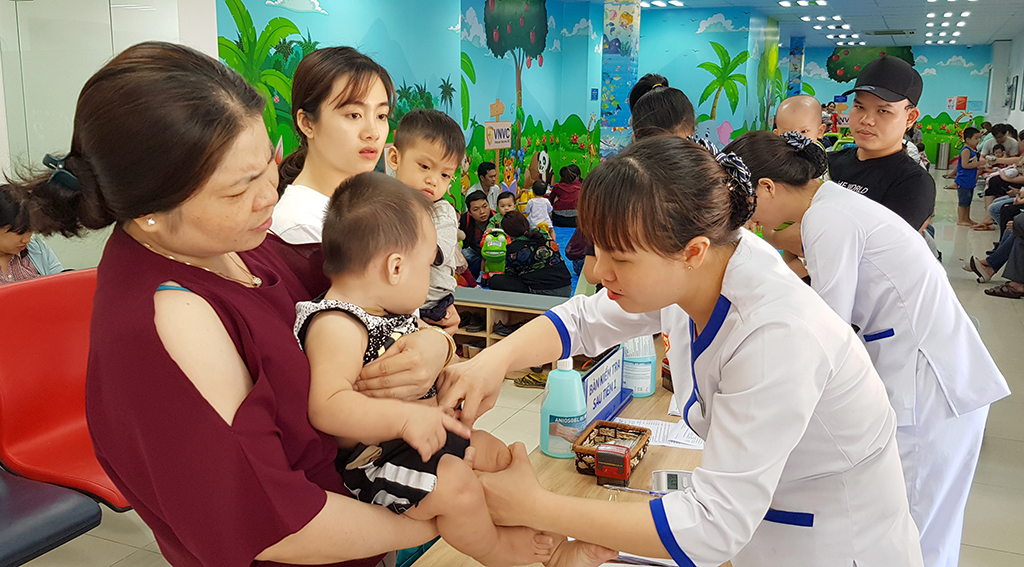 Rất đông phụ huynh đưa trẻ đến tiêm vắc xin tại một điểm tiêm dịch vụ ở TP.HCM ẢNH: DUY TÍNH