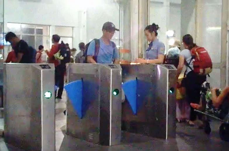 Nhân viên ở ga Sài Gòn (nữ) quẹt mã vạch trên vé hợp lệ để cửa tự động mở cho khách qua