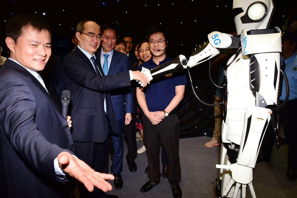 Bí thư Thành ủy TP.HCM Nguyễn Thiện Nhân bắt tay robot được điều khiển bằng sóng 5G Ảnh: Cẩm Thủy