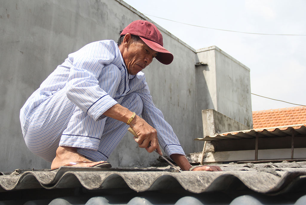 Người dân ở TP.Quy Nhơn (Bình Định) gia cố lại mái nhà trước khi bão đến ẢNH: BẢO THOA