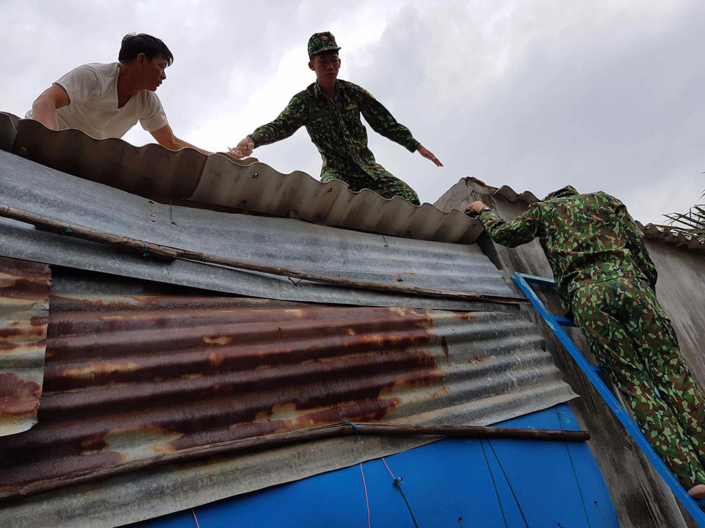 Bộ đội biên phòng giúp người dân xã Cát Khánh (H.Phù Cát, Bình Định) chằng chống nhà cửa ẢNH: CÔNG CƯỜNG