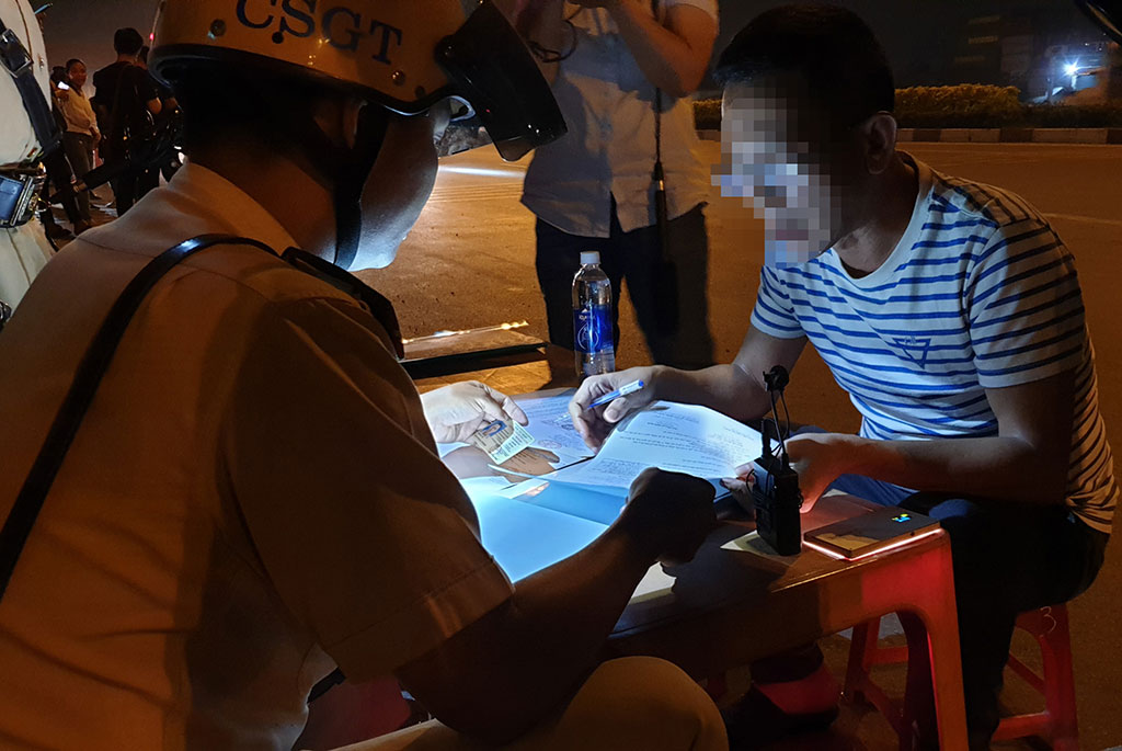 Đội CSGT Rạch Chiếc lập biên bản đối với tài xế vi phạm nồng độ cồn trên xa lộ Hà Nội tối 4.1 Ảnh: Sỹ Đông