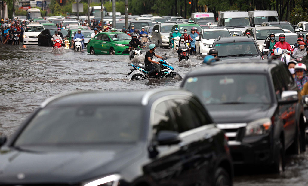 Hàng ngàn người dân TP.HCM vất vả lội nước trên đường Nguyễn Hữu Cảnh trong cơn mưa chiều 3.6 Ảnh: Ngọc Dương