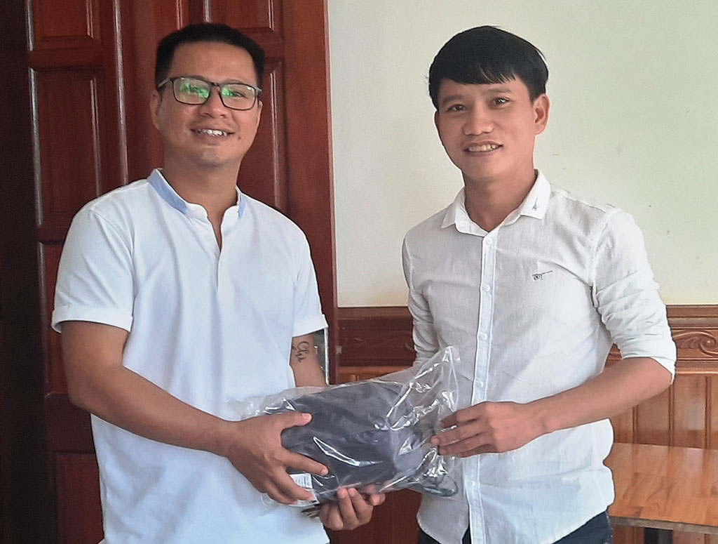 Đại diện Báo Thanh Niên (phải) trao tặng bộ áo quần đi mưa chuyên dụng cho các phóng viên để tác nghiệp trong mùa bão lũ ẢNH: M.C