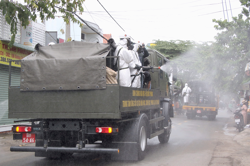Lực lượng phòng hóa của Quân khu 7 (áo trắng) phối hợp với Ban chỉ huy quân sự TP.Thủ Đức phun khử khuẩn trên một số tuyến đường và khu dân cư ngày 23.7 ẢNH: KHẢ HÒA