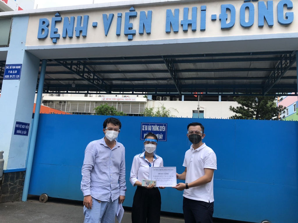 Anh Thuật (phải) gửi tiền cho một tình nguyện viên để vào Bệnh viện Nhi đồng 1 trao cho các bệnh nhi