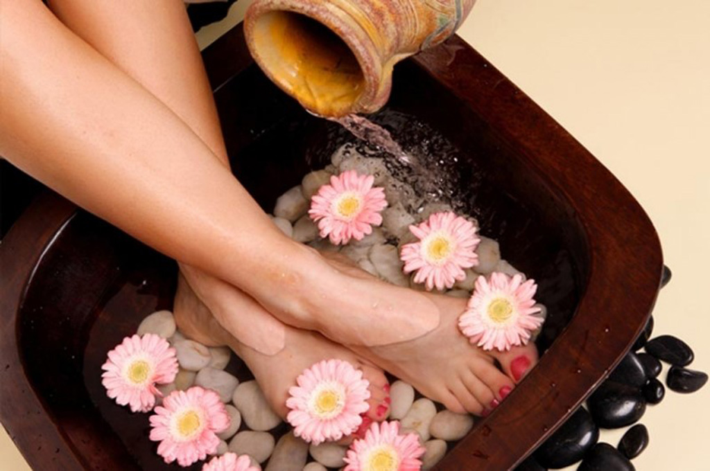 Ngâm chân với đá và bồn ngâm chân gỗ trong liệu trình foot massage